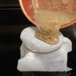 pouring flaxseed through a sieve to create a lube