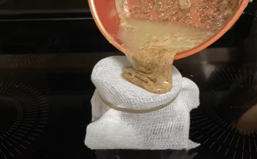 pouring flaxseed through a sieve to create a lube